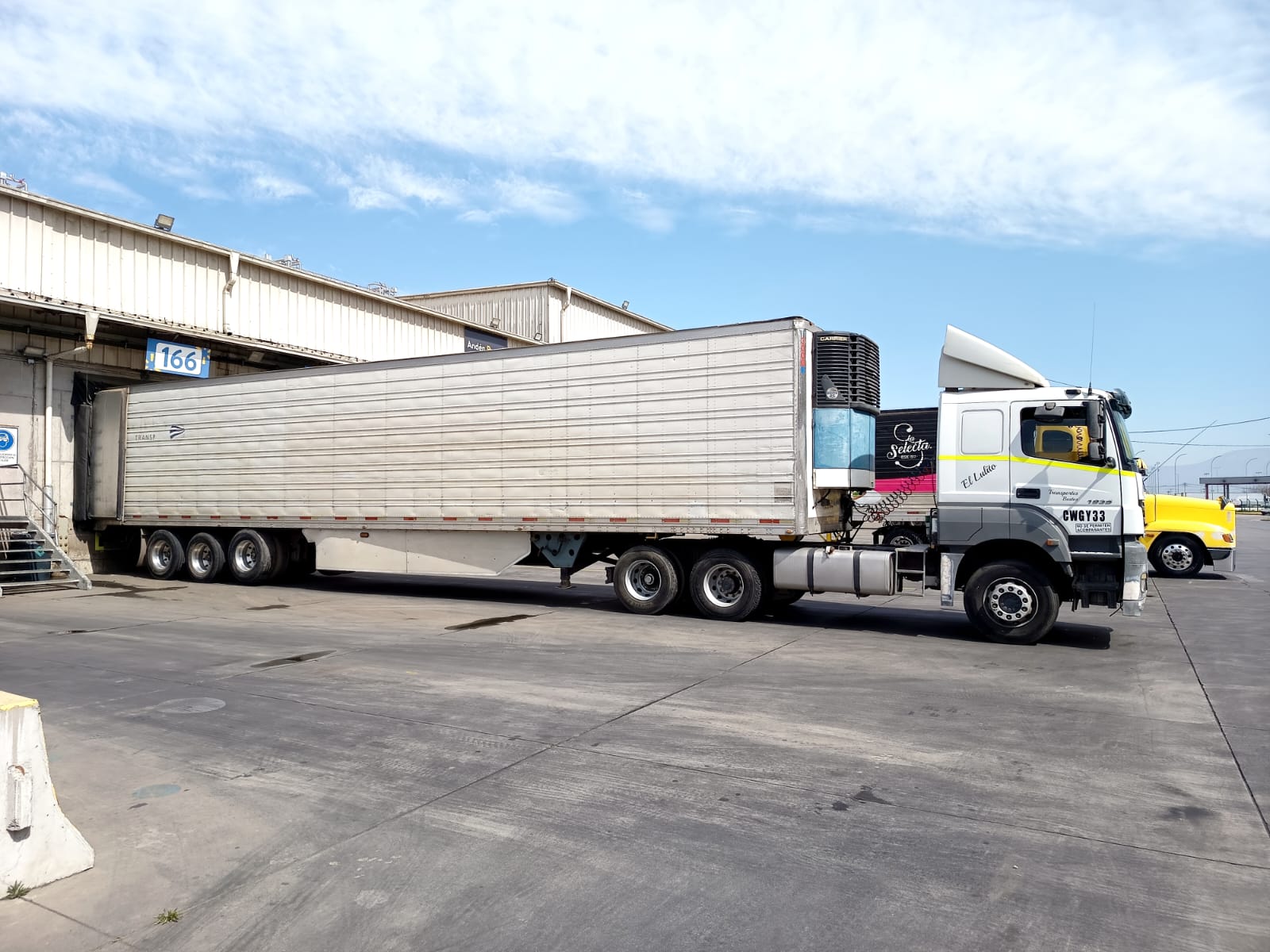 Camión rampla refrigerada en andén de carga